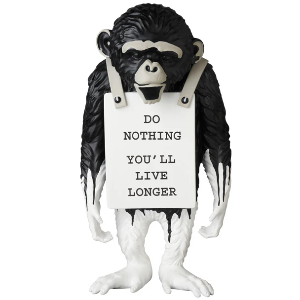 Monkey figurine holding a sign with humorous text on a white background