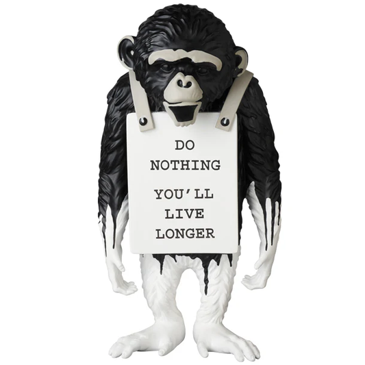 Monkey figurine holding a sign with humorous text on a white background